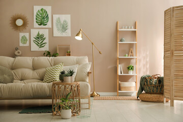 Sticker - Stylish living room interior with comfortable sofa and beautiful pictures on wall