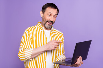 Sticker - Photo of happy mature cheerful man look hold laptop online meeting isolated on purple color background