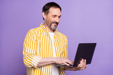 Photo portrait bearded man in striped shirt smiling using laptop working isolated pastel violet color background