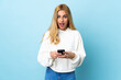 © luismolinero - Young Uruguayan blonde woman over isolated blue background surprised and sending a message