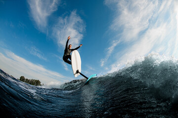 Beautiful view of sportive man riding on the wave with hydrofoil foilboard