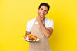 © luismolinero - Restaurant waiter holding waffles over isolated yellow background happy and smiling