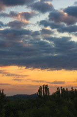 Wall Mural - Landscape with dramatic light - beautiful golden sunset with saturated sky and clouds.