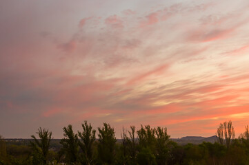 Wall Mural - Landscape with dramatic light - beautiful golden sunset with saturated sky and clouds.