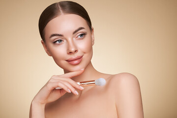 Wall Mural - portrait beautiful young woman with clean fresh skin. model with cosmetic makeup brush. cosmetology,