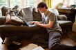 © Sam Edwards/Caia Image - Focused teenage boy with laptop studying in living room at home