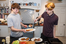 Teenage Boys Making Hamburgers In Kitchen