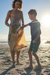 © Trevor Adeline/Caia Image - Mother and son volunteering picking up garbage on sunny beach