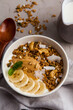 Smoothie bowl with banana, granola and coconut on a table, closeup view. Healthy vegan detox smoothie bowl, superfood