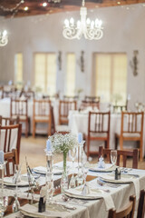 Canvas Print - Tables in a wedding hall decorated with flowers and glass candleholders