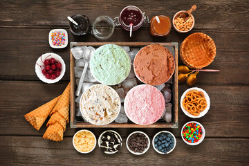 Aufkleber - Summer ice cream buffet with a variety of flavors and sweet toppings. Overhead view table scene on a dark wood background.