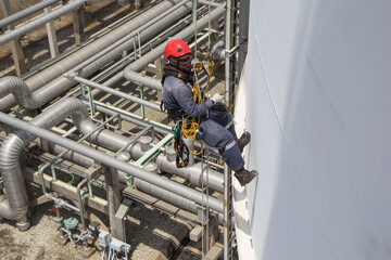 Top view male worker rope access  inspection of thickness storage tank industry