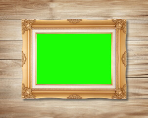 Poster - The antique gold frame on wooden wall background , for Graphics design.