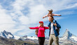 Happy family with little child doing trekking on switzerland mountain in summer time. Young people having fun in landscape nature. Concept of travel, friendly family