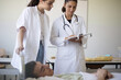 © liderina - Young student girl in patient room with professor, checking results.