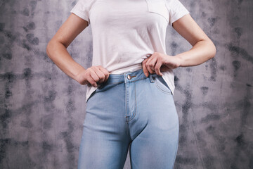 young woman pulls on jeans