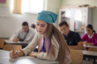 © liderina - Teenagers students sitting in the classroom working exam.