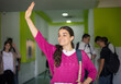 © liderina - Smiling student girl waving to her friend.