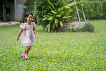 Wall Mural - Adorable Little Thai girl running at field