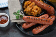 Cast-iron tray with traditional german bratwurst and sauerkraut, selective focus, close-up