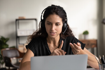 Poster - Young woman in headphones talk on video call on computer, consult client customer on web. Confident millennial female in earphones have webcam digital virtual event on laptop. Communication concept.