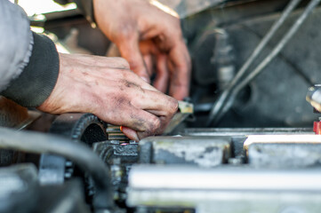 Mechanic repairing car with dirty hands in oil