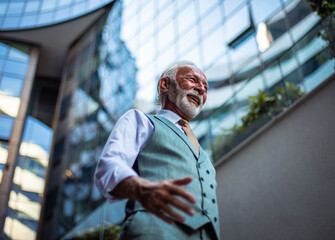 Wall Mural - Cheerfully Senior business man walking trough street.