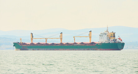 Huge container tanker ship carrying truck size colourful containers in deep blue open ocean sea