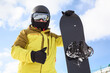 Snowboard and snowboarder with thumb up. Man wearing helmet, goggles and gloves. Extreme winter sport