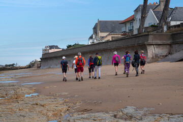 A group of friends hiking on a beach in Brittany, France