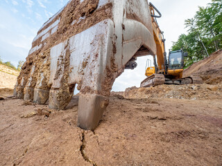 Detailed earth crack under bucket of heavy quarry loader in open mine