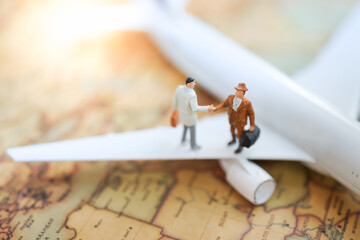 Miniature business people standing on airplane using as success and leadership background travel or business trip traveler adviser agency or online world wide marketing concept