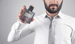 © andranik123 - Man holding a bottle of perfume.