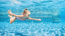 Funny Portrait Of Child Learning Swimming, Dive In Blue Pool With Fun - Jumping Deep Down Underwater With Splashes. Healthy Family Lifestyle, Kids Water Sports Activity, Swimming Lesson With Parents.