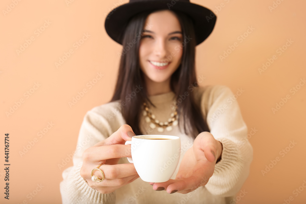 Beautiful young woman drinking coffee on color background, closeup