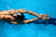 © ADDICTIVE STOCK - Sportsman in goggles swimming in pool during workout