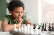© Pixel-Shot - Cute African-American boy playing chess at home