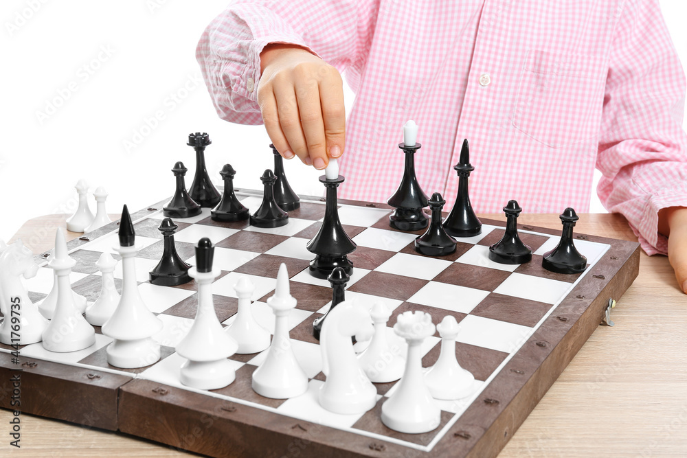 Cute little girl playing chess on white background