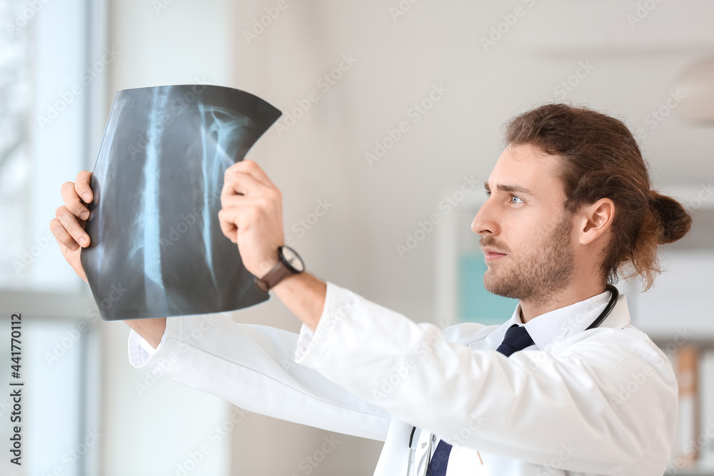 Young doctor with x-ray image of lungs in clinic