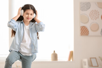 Cute little girl listening to music at home