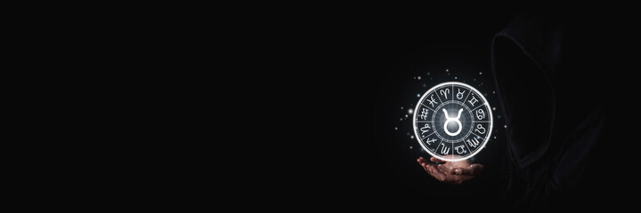 Wall Mural - female hands holding the luminous astrological signs of the zodiac in a circle on a black background