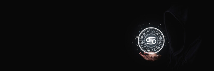 Wall Mural - female hands holding the luminous astrological signs of the zodiac in a circle on a black background