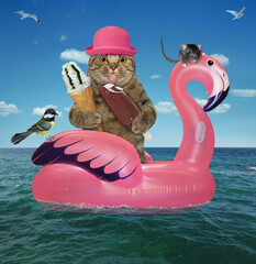 Canvas Print - A beige cat in a pink straw hat with ice cream is floating on an inflatable flamingo in the sea at a resort.