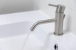 Hygiene concept, Selective focus of grey stainless water faucet with wash basin, Interior of bathroom with taps and sinks, Modern design of toilet, Sanitary ware with white colours. 