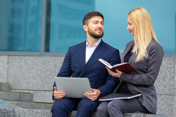 Wall Mural - successful businessmen man and woman with documents and laptop in hands discuss business projects