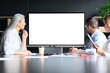 © insta_photos - Global corporation online video chat business webinar in meeting room with multiethnic diverse colleagues in office watching big empty blank white screen monitor. Business technologies concept.