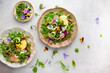 Delicious summer salad with edible flowers, vegetables, fruit, microgreens and cheese. Clean and healthy eating concept. Top view.