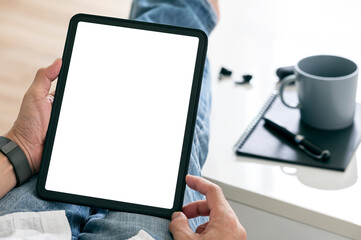 Wall Mural - cropped shot of man hands using tablet with blank screen while sitting in living room at home.