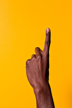 Black Man Raising Index Finger Against Yellow Background