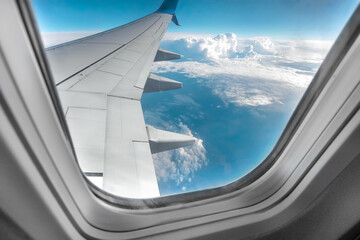 View from the window of a passenger plane above the clouds. International cargo transportation, air travel, transport, air travel, vacations. Copy space.